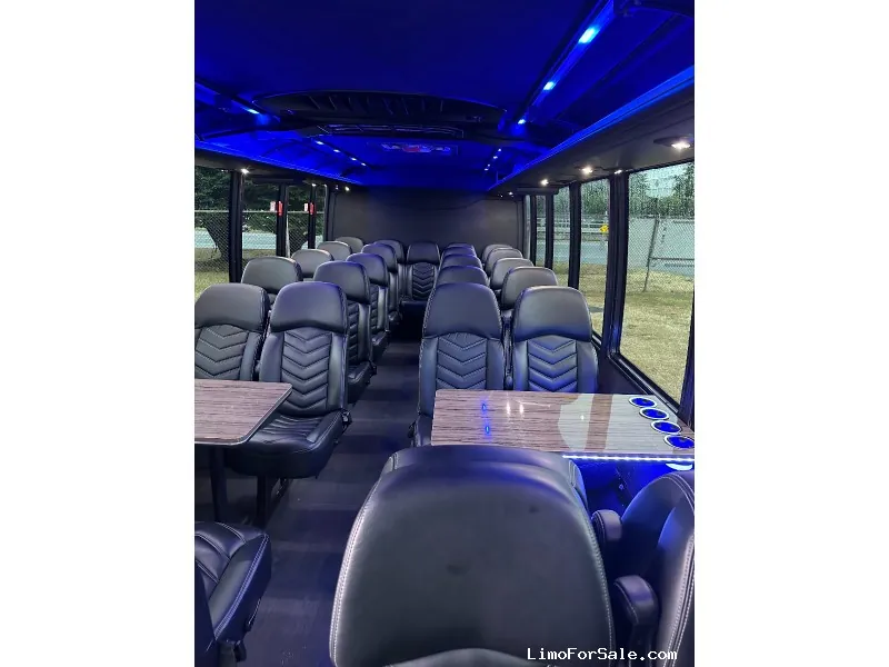 Mini-coach interior with leather seats, tables and LED lighting for group transportation in Calgary